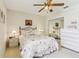 Comfortable bedroom featuring a ceiling fan, mirrored closet doors, and dresser for ample storage at 5135 Aurora Dr, Leesburg, FL 34748