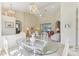 Bright dining area featuring a glass table, white wicker chairs, and an elegant chandelier at 5135 Aurora Dr, Leesburg, FL 34748