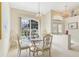 Bright dining area with a glass-top table, stylish chairs, and natural light streaming through large windows at 5135 Aurora Dr, Leesburg, FL 34748