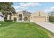 Inviting single-story home with lush green lawn, a two-car garage, and manicured shrubbery at 5135 Aurora Dr, Leesburg, FL 34748