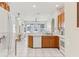 Open-concept kitchen with wood cabinets and a view into the combined dining and living areas at 5135 Aurora Dr, Leesburg, FL 34748