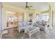 Enclosed sunroom with slate tile, wicker furniture, ceiling fan, and view to the exterior at 5135 Aurora Dr, Leesburg, FL 34748