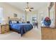 Bright main bedroom featuring a ceiling fan, neutral carpeting, and an outside view from the sliding glass doors at 5135 Aurora Dr, Leesburg, FL 34748