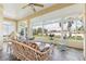 Beautiful sunroom featuring a floral-patterned sofa, a ceiling fan, and multiple windows with a stunning view at 5135 Aurora Dr, Leesburg, FL 34748