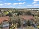 An aerial view of homes with terra cotta tile roofs nestled among lush trees near a lake at 5466 Compass Pt # 101, Oxford, FL 34484