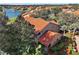 An aerial view of a home with terra cotta roof near a lake and tropical greenery at 5466 Compass Pt # 101, Oxford, FL 34484