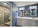 The bathroom features a double sink vanity, framed mirrors, great lighting, and a walk-in shower at 5466 Compass Pt # 101, Oxford, FL 34484