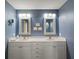 This full bathroom features a double sink vanity with framed mirrors and great lighting at 5466 Compass Pt # 101, Oxford, FL 34484