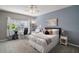 Comfortable bedroom with a ceiling fan, a bed with a grey headboard, a desk and chair, and light-blue walls at 5466 Compass Pt # 101, Oxford, FL 34484