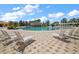 Relaxing community pool area featuring ample lounge chairs, palm trees, and a waterfall feature at 5466 Compass Pt # 101, Oxford, FL 34484
