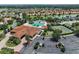 Aerial view of a community pool with a waterfall feature, tennis court and ample parking at 5466 Compass Pt # 101, Oxford, FL 34484
