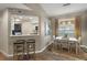 A stylish dining room and bar features a modern table, pendant lighting, and warm, neutral tones at 5466 Compass Pt # 101, Oxford, FL 34484