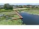 Scenic lake view with a dock surrounded by water lilies and lush greenery at 5466 Compass Pt # 101, Oxford, FL 34484