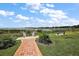 Scenic view of a lake with a brick path, lush grass and a park bench at 5466 Compass Pt # 101, Oxford, FL 34484