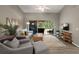 Bright living room with wood floors, a ceiling fan, and sliding glass doors leading to the outdoor patio at 5466 Compass Pt # 101, Oxford, FL 34484