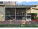 Backyard view of a screened porch with outdoor seating, providing a private and relaxing space at 5466 Compass Pt # 101, Oxford, FL 34484