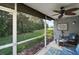 Inviting screened porch with cozy seating, a fan, and a view of the landscaped yard at 5466 Compass Pt # 101, Oxford, FL 34484
