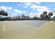 Outdoor tennis court in a residential community with lush green landscaping and clear blue skies at 5466 Compass Pt # 101, Oxford, FL 34484