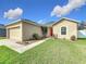 Charming single-story home featuring a two-car garage, a red front door, and well-maintained landscaping at 5891 Forest Ridge Dr, Winter Haven, FL 33881