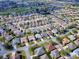 Aerial view of a residential community near a golf course and lake at 591 Statesburg St, The Villages, FL 32162