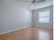 Empty bedroom with hardwood floors, a ceiling fan, and a bright window at 591 Statesburg St, The Villages, FL 32162