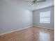 Bright bedroom with light gray walls, wood floors, and a ceiling fan at 591 Statesburg St, The Villages, FL 32162