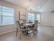 The dining room features modern decor, a stylish light fixture, and views from the large windows, creating an inviting space at 591 Statesburg St, The Villages, FL 32162