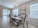Well-lit dining room presents a modern chandelier, a stylish wood table, views to the lanai, and neutral decor at 591 Statesburg St, The Villages, FL 32162