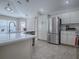 Bright kitchen features white cabinetry, stainless steel appliances, pendant lighting, a large sink, and views to the dining area at 591 Statesburg St, The Villages, FL 32162