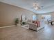 Comfortable living room features neutral tones, a vaulted ceiling, and tile flooring throughout at 591 Statesburg St, The Villages, FL 32162