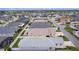 An aerial view captures a quiet residential street with well-maintained homes, manicured lawns, and fenced backyards for privacy at 5934 Kaplan Ct, The Villages, FL 32163