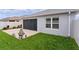 Exterior view of home showcasing a screened-in lanai, well-maintained lawn, and a concrete patio at 5934 Kaplan Ct, The Villages, FL 32163