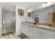 Well-lit bathroom with dual sinks, walk-in shower, and convenient linen storage at 5934 Kaplan Ct, The Villages, FL 32163