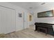 Bright bedroom featuring a piano, and light, wood-look flooring, closet, and an attached bathroom at 5934 Kaplan Ct, The Villages, FL 32163