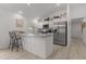 Bright kitchen featuring modern stainless steel appliances, neutral countertop, and an eat-in breakfast bar at 5934 Kaplan Ct, The Villages, FL 32163