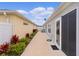 Exterior side view with neat landscaping leading to a screened patio and yard at 5934 Kaplan Ct, The Villages, FL 32163