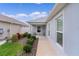 Exterior side view of home showcasing a covered entry, manicured landscaping at 5934 Kaplan Ct, The Villages, FL 32163