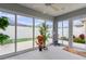 Enclosed sunroom featuring sliding glass doors, ceiling fan, neutral flooring, and multiple plants at 5934 Kaplan Ct, The Villages, FL 32163