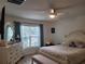Serene bedroom featuring natural light, a ceiling fan, a comfortable bed, and stylish furnishings at 7133 Sw 135Th Pl, Ocala, FL 34473