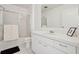Clean bathroom with white vanity, ample lighting, shower with glass doors, and tiled flooring at 731 Hernandez Dr, The Villages, FL 32159