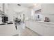 Eat-in kitchen with white cabinetry, stainless steel sink, and modern appliances overlooking the dining area at 731 Hernandez Dr, The Villages, FL 32159