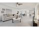 Bright and airy living room featuring neutral tones, ceiling fan, and seamless transition to dining area at 731 Hernandez Dr, The Villages, FL 32159