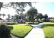 Well-maintained walkway winds through the community, surrounded by lush greenery and landscaping at 731 Hernandez Dr, The Villages, FL 32159