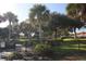 Gated entrance to the community showcasing lush landscaping and mature palm trees at 731 Hernandez Dr, The Villages, FL 32159