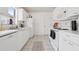 Efficient white kitchen with modern appliances, ample counter space, and neutral-toned tile flooring at 731 Hernandez Dr, The Villages, FL 32159