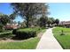 Scenic pathway meandering through mature trees, lush landscaping, and inviting green spaces at 731 Hernandez Dr, The Villages, FL 32159