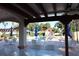 Inviting pool area featuring ample seating under a shaded pergola and pristine landscaping at 731 Hernandez Dr, The Villages, FL 32159