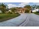 Charming single-story home featuring a well-maintained lawn, mature palms, and a curved driveway leading to the garage at 737 Bolivar St, The Villages, FL 32159