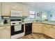 Cozy kitchen features light cabinets, tile flooring, and window over sink at 737 Bolivar St, The Villages, FL 32159