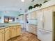Cozy kitchen features light cabinets, tile flooring, and breakfast bar at 737 Bolivar St, The Villages, FL 32159